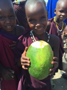 Maasai child showing me a wild papaya fruit 